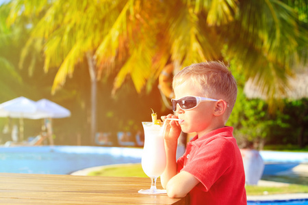 喝鸡尾酒的热带海滩上的小男孩