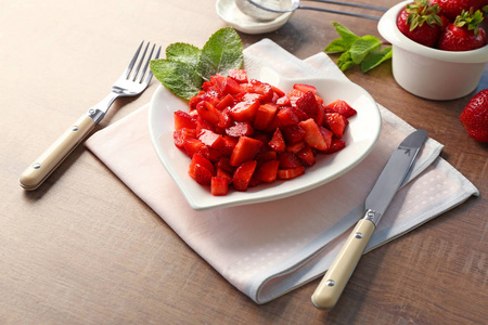 美味切片的草莓心形板木制的桌子上