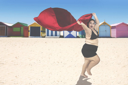 肥胖女人与围巾在海岸图片