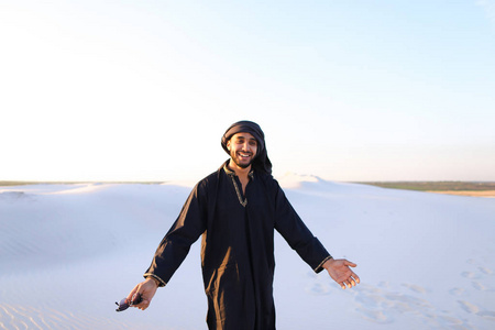 开心的家伙阿拉伯，穿过沙漠，微笑和享有李