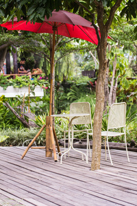 椅子和红伞在花园里的餐桌