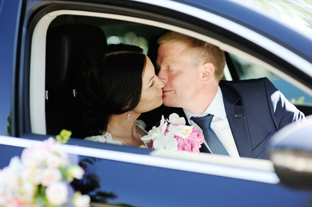 新娘和新郎在婚礼车正在亲吻