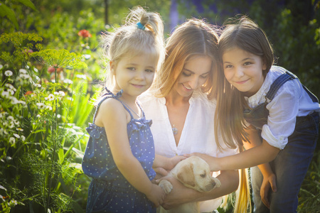 幸福的女人和她的女儿与拉布拉多小狗