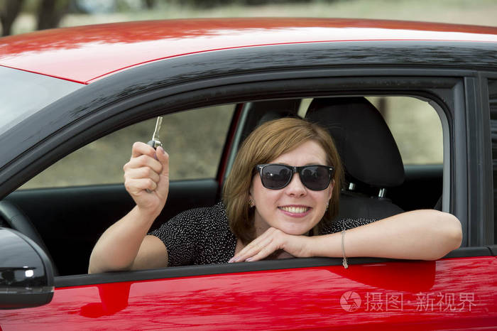 照片 有魅力的女人微笑骄傲坐在驾驶员座位上抱着和车钥匙示新汽车