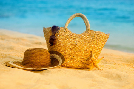 包的帽子和眼镜在海滩上