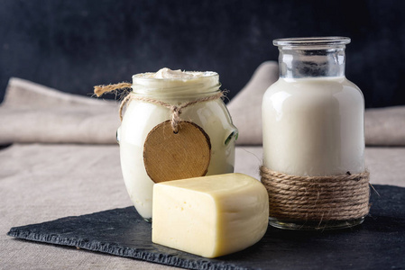 生态农场产品牛奶 奶酪 酸奶 酸奶上深色木制背景。自制天然食品的概念