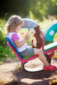 小女孩正在玩一只玩具熊