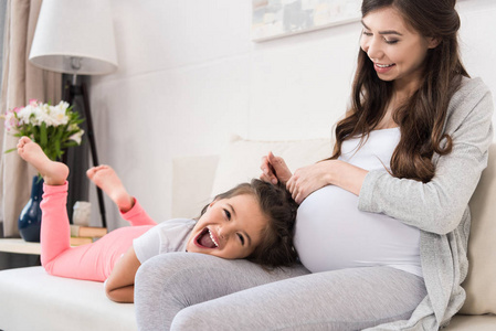 孕妇与女儿躺在腿上