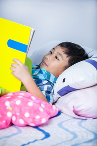 亚洲男孩读一本书。教育理念