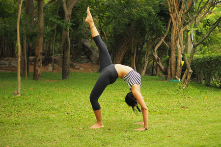 年轻女人做瑜伽练习中花园公园