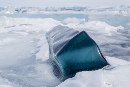 在冰冻的贝加尔湖表面有一大块深蓝色的方形冰块