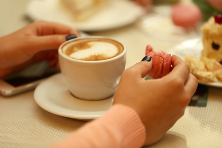 一杯咖啡和蛋糕在咖啡馆里的女人