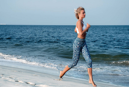运动健身女人在海滩上运行。户外锻炼