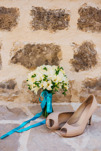 婚礼的新娘和一束白色的花从新娘的鞋子