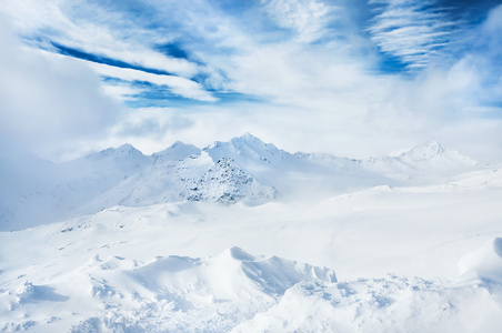 冬天白雪覆盖的山脉和蓝天与白云