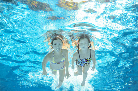 孩子们在水下，快乐积极的女孩已经在水里，孩子们运动家庭度假的乐趣的游泳池里游泳