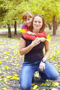 母亲和女儿在秋天公园享受周末