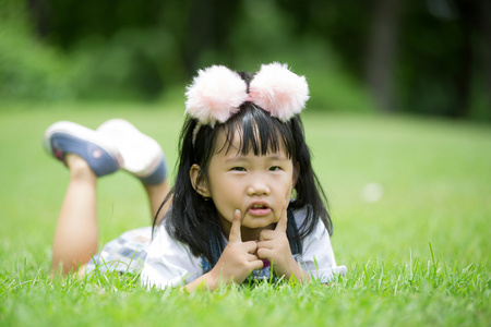 在公园里的绿草地上玩耍的小亚洲女孩