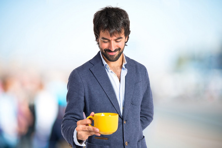 男子捧着一杯咖啡，在白色的背景