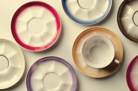 空的五彩瓷器餐具，杯子和盘子在灰色的背景上。定了调子