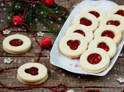 传统的自制圣诞饼干林茨饼干充满红色的果酱，木制的背景上。选择性的焦点