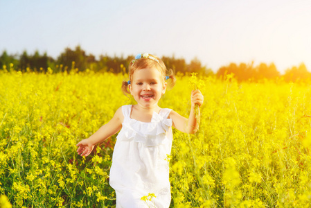 快乐的小小孩的女孩，在花呈黄色字段上运行
