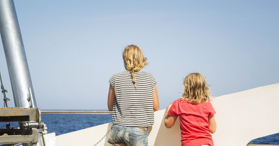 孩子们从一艘船的甲板上看着大海