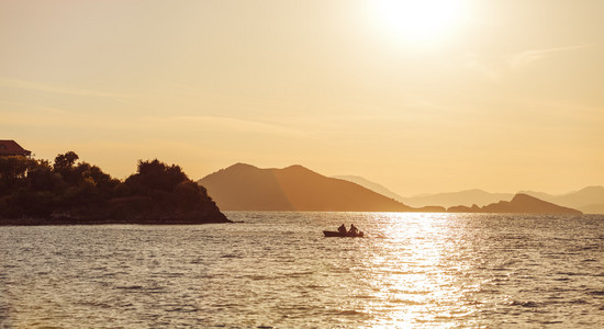 美丽的日落的海面上，在山脉背景