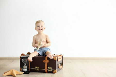 adorble 的小男孩坐在老式的手提箱