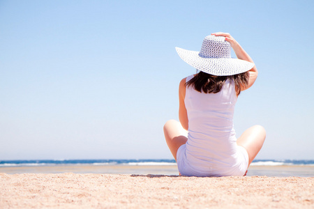 年轻女子坐在沙滩上