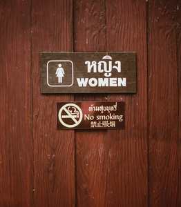 女厕所标志和禁止吸烟标志的木墙
