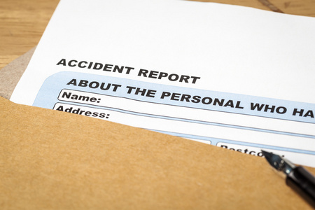 事故报告申请表和棕色信封，业务上的钢笔