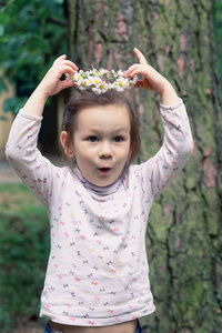 小女孩用雏菊在她头上的花环