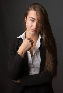 高时尚的年轻优雅苗条黑发女人摆在工作室里穿着时髦的黑色夹克西装和白色衬衫的肖像