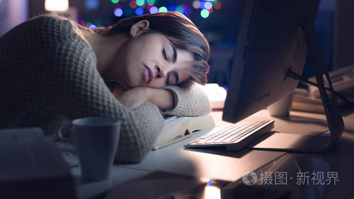 疲惫的年轻女人睡在办公桌上深夜, 失眠和疲惫的概念