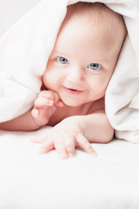 洗澡后的快乐宝宝看着白色毛巾笑着