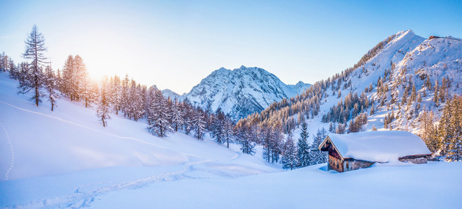 在阿尔卑斯山小屋在日落时以冬季仙境