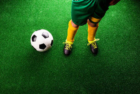 在绿色草地上的小足球运动员。