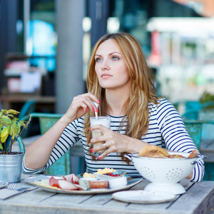 年轻女子在户外咖啡馆吃健康早餐