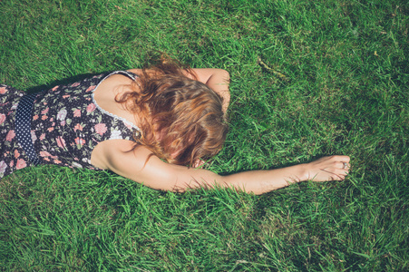 在一个夏日躺在草地上的年轻女子