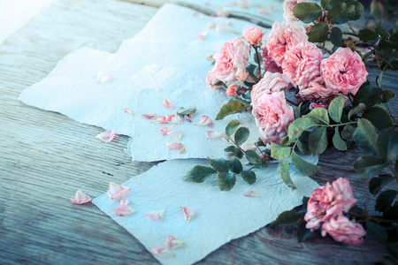 粉色玫瑰用木制的桌子上的文件