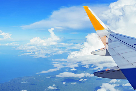 飞机机翼多云的蓝色天空和地球从窗口视图