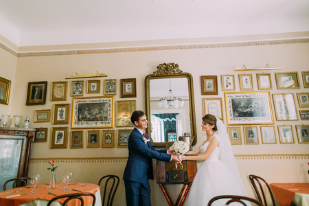 祝新婚快乐新娘和新郎后他们的婚礼在复古咖啡馆与美丽的复古室内摆姿势