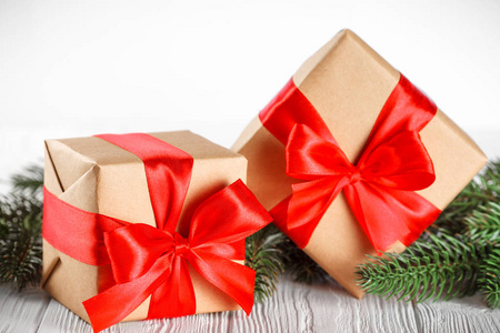 工艺礼品盒用红丝带和蝴蝶结，绿色的圣诞树，装饰，白色木制背景上。圣诞节和新年贺卡 横幅 传单