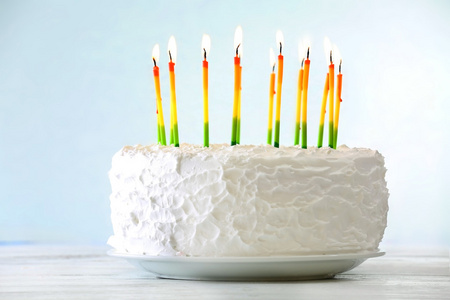 浅色背景上的蜡烛的生日蛋糕