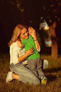 在公园中拥抱着爱她的儿子的母亲