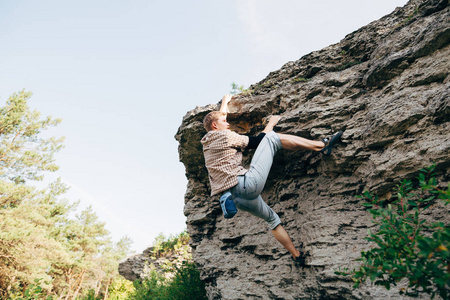 男子攀爬岩石图片