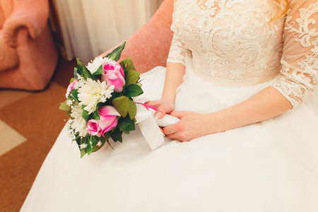美丽的新娘穿着白色婚纱，拿着花束