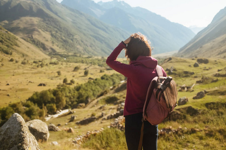 一个年轻的妇女旅行者背包欣赏秋山视图, 后视图