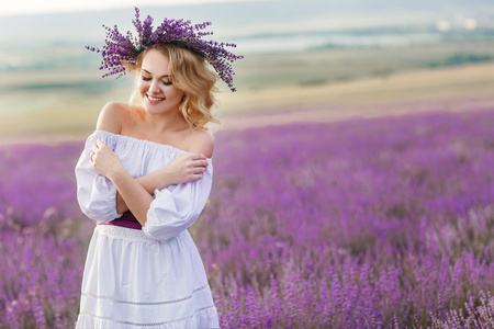 美丽的女人在一片盛开的薰衣草的田野里